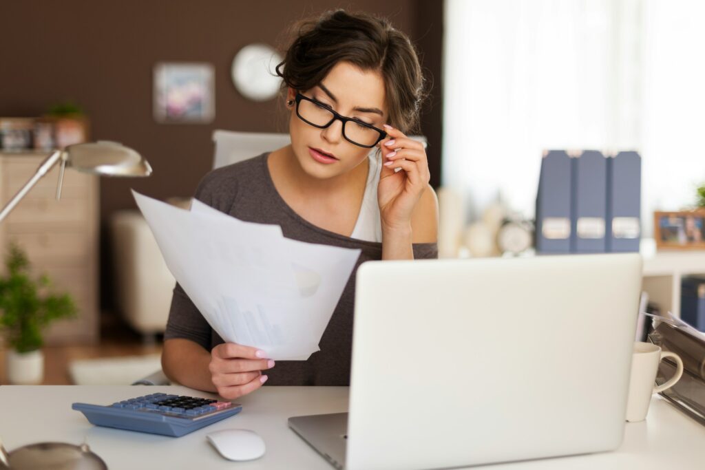 Person calculating budgets and reviewing financial documents used in a divorce appraisal and support calculation.